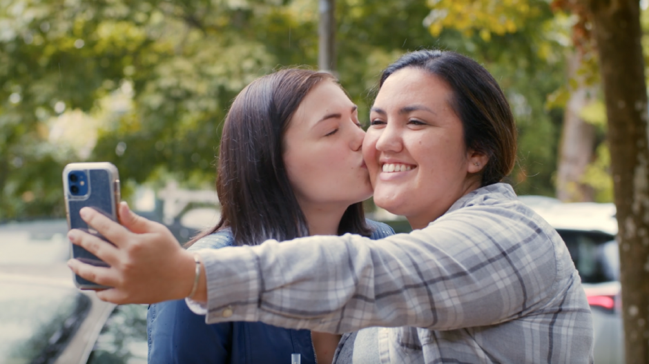 Erika kisses Janine's cheek while Janine takes a selfie